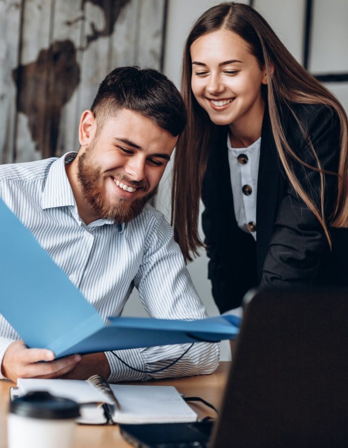 A smiling manager and his assistant work in the office