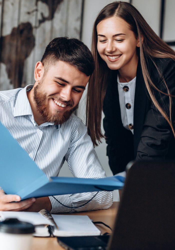 A smiling manager and his assistant work in the office
