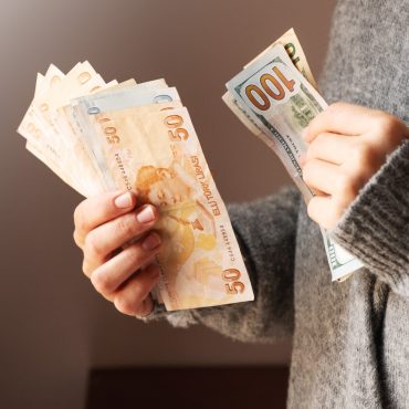 Woman holding in hands Turkish lira and American dollar’s.Currency or economy crisis